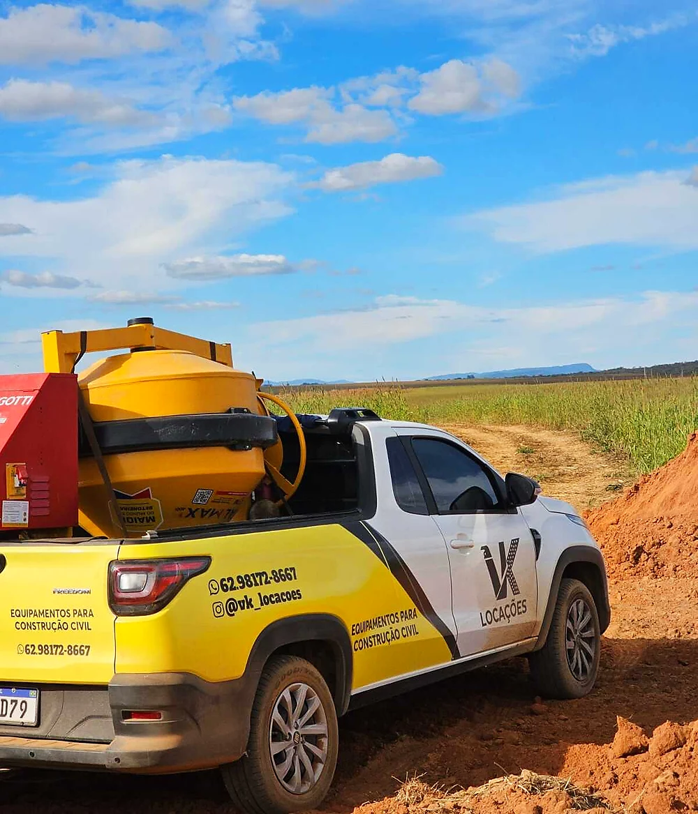 Caminhonete da VK Locações transportando betoneira em estrada rural de Uruaçu-GO